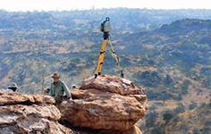 一位土地测量员站在岩层顶端